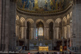 <center>Basilique du Sacré-Cœur de Montmartre </center>   Le chœur de la basilique du Sacré-Cœur de Montmartre et son retable en marbre de Carrare. Le chœur est fermé par onze arcades romanes, étrangement allongées.