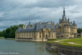 <center>Le château de Chantilly. </center> Chantilly fut d'abord une ancienne forteresse médiévale cantonnée de sept tours et entourée de douves en eau, construite sur un terrain marécageux de la vallée de la Nonette, qui contrôlait la route de Paris à Senlis. Le château appartenait primitivement à Guy de Senlis, « bouteiller » du roi Louis VI à la fin du XIe siècle. La puissante famille des Montmorency possède Chantilly du XVe au XVIIe siècle et y fait réaliser d'importants travaux de modernisation. C'est le plus illustre membre de cette famille, le connétable Anne de Montmorency (1492-1567), qui fait rénover la forteresse par Pierre Chambiges en 1528 et, en 1551, construire, au pied de la vieille forteresse, la Capitainerie ou Petit Château (au premier plan), par l'architecte Jean Bullant, qui avait travaillé dans son château d'Écouen. Il fait également aménager en 1538 la terrasse sur laquelle se dresse actuellement sa statue équestre et édifier sept chapelles dont deux ont été conservées à l'intérieur du parc. C'est également lui qui fait tracer les premiers jardins.