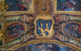 <center>La galerie des Glaces. </center>Protection accordée aux beaux-arts, 1663. Louis XIV est assis sur son trône et accueille l’Académie française ou bien une allégorie de l’Éloquence ; d’autres Arts ou Académies sont représentés à l’arrière-plan. La Paix conclue à Aix-la-Chapelle, 1668 : Pour marquer la conclusion de la paix, Louis XIV tend à l’Espagne un rameau d’olivier. La Franche-Comté est à genoux, à gauche du roi, au milieu d’armes éparses. L’Ordre rétabli dans les finances, 1662 : Le roi est peint assis sur son trône, s’appuyant sur le timon du gouvernement et désignant en même temps les Harpyes pourchassées par Minerve (celle-ci, symbolisant la Sagesse royale). Les Harpyes symbolisent les « partisans », c’est-à-dire les financiers qui avançaient des sommes importantes à l’État en contrepartie du prélèvement des impôts indirects. Ils étaient détestés par le peuple et devaient régulièrement rendre des comptes lors de chambres de justice. Louis XIV tient dans la main gauche la clef d’or de la cassette du trésor royal qu’il tend à la Fidélité, tandis que celle-ci lui montre les livres des comptes : cette allégorie désigne certainement Colbert en tant que contrôleur général des finances. L’allégorie de la France suppliante est à genoux devant le roi.