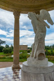 <center> Le Temple de l’Amour.</center> Pour orner le centre du temple, la reine refusa le groupe proposé par Deschamps et fit installer une copie de la statue de Bouchardon, L’Amour taillant son arc dans la massue d’Hercule (1750), prévue à l’origine pour le salon d’Hercule et reléguée au château de Choisy en 1752. Marie-Antoinette fit rapatrier l’œuvre au Louvre pour qu’elle y soit copiée par le sculpteur Louis-Philippe Mouchy. La copie de Mouchy quitta Trianon à la Révolution, séjourna quelques temps à Saint-Cloud puis fut replacée dans son cadre d’origine en 1816.