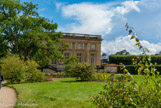 <center> Le Petit Trianon.</center> Le bâtiment adopte une forme cubique extrêmement simple ; sa toiture est dissimulée par une balustrade. Gabriel a su éviter un traitement décoratif trop simple ou trop austère en variant le traitement réservé aux façades du château qui offrent toutes cinq ouvertures par étage. Si la façade méridionale (photo précédente), sur la cour d’honneur, est sobrement ornée de quatre pilastres soulignant une légère saillie des trois travées centrales, la façade nord reprend ce traitement mais avec un étage en moins à cause de la différence de niveau ; la façade est, qui donnait sur le jardin botanique de Louis XV, est la plus sobre ; en revanche, la façade occidentale, donnant sur le Jardin français, a reçu un traitement très soigné en étant savamment mise en valeur par une élégante terrasse et rehaussée par quatre majestueuses colonnes corinthiennes qui créent un léger avant-corps.