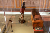 <center>Microscope et son étui France.</center>Seconde moitié du XVIIIe siècle. Bois peint, cuir, ivoire et cuivre.
Don Mario G robot, 1919.
Marseille, Musée Grobet-Labadié.
Au temps des Lumières, les instruments de mesure, de précision et d'investigation scientifique connaissent un succès croissant, notamment auprès de la noblesse qui accorde un intérêt tout particulier aux sciences et techniques. Ce microscope de type Culpeper est issu des collections d’objets de curiosité réunis par Marie Grobet qui en entretint le goût durant toute son existence. Il offre, sur son socle, son fût et sa lunette, un traitement décoratif imitant les laques dans le goût chinois. Ce type de décor, parfois rehaussé d'or et de vernis, pouvait s’apprécier non seulement sur des meubles de fantaisie, cadres et cartels, mais aussi sur des coffrets en tous genres, qu'il s'agisse de bottes à perruques, de bottes à thé, d'étuis é messages ou de nécessaires de voyage qui parsemaient le cadre de vie des classes favorisées au XVIIIe siècle.