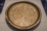 <center>Grand plat damasquiné au nom de l'émir Qulunjaq</center>Egypte ou Syrie
Vers 1270
Cuivre et incrustations d'argent
Institut de France, Musée Jacquemart-André, Paris. <br> Cet objet d'apparat reflète la popularité de l'astrologie dans les milieux princiers. Sur ce plateau, le cercle des planètes et celui du zodiaque entourent trois médaillons portant le blason du commanditaire, ils symboliseraient les trois visages du Soleil. Le prince, assimilé au Soleil, est ainsi inscrit dans un cadre cosmique.