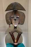 <center>Mboy Figure de reliquaire Kota
Gabon</center>Fin XIXe s.-début XXe s.
Bois sculpté, cuivre et laiton martelés
Donation Léonce, Pierre, Michel Guerre
Musée d'Arts Africains, Océaniens, Amérindiens, Marseille. <br>
Les Kotas vivant au sud-est du Gabon conservent les reliques des ancêtres dans de grands paniers en vannerie, surmontés de la partie supérieure, seule visible, d'une figure sculptée de gardien des reliques nommée mboy. Associés à des rituels funéraires, les paniers sont préservés à l'abri des regards, dans une hutte réservée aux initiés.
Les rites accomplis permettent en premier lieu d'éloigner les défunts du lignage dont le corps est emporté en forêt tandis que la tête, fumée, est placée dans le reliquaire. Ils ont également pour fonction d'honorer ces ancêtres, afin de bénéficier de leur protection. La partie inférieure de la figure sculptée est intégrée au panier et sert ainsi d'élément de fixation. Lors de certaines cérémonies, le reliquaire seul, tenu par cette base en forme de losange, peut également être brandi.
Giacometti avait acquis auprès de son ami suisse Serge Brignoni une statue de reliquaire Kota, visible dans une photographie de son ami suisse Serge Brignoni une statue de reliquaire Kota, visible dans une photographie de son appartement-atelier rue Hippolyte-Maindron è Paris en 1927, l'une des rares pièces provenant d'autres continents qu'il ait possédées.
L'esquisse rapide sur la page d'un catalogue d'une figure très similaire reflète son regard, des décennies plus tard, sur ce type de production.