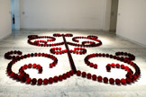 <center></center>James Lee BYARS
1932, Detroit (États-Unis) 1997, Le Caire (Égypte)
Le petit ange rouge
1991-1993
Verre massif travaillé à chaud.
Inv. 1993.8.1
Production / réalisation Cirva Collection Cirva. Marseille.
Après des études de philosophie et d'art dans sa ville natale James Lee Byars découvre le Japon, qui sera pour lui une source d'inspiration capitale. Il y développe l'idée qu'un concept seul peut être un objet esthétique, ce qui deviendra un thème pour le reste de sa carrière. Son travail de performances, installations et sculptures, empreint de spiritualité prend source dans différentes cultures, mythologies et philosophies, à la fois orientales et occidentales, archaïques et tribales. Il est hanté par l'éphémère et la mort
Ainsi The Rose Table of Perfect (1989), où les 3333 roses rouges qui composent la sculpture se fanent tout au long de l'exposition. Et The Perfect Death of James Lee Byars (1984) dans laquelle l'artiste est vêtu d’un costume en lamé or et étendu sur le sol peint en or. Son corps, ton sur ton, se fond dans la couleur.
Le Petit Ange rouge est composé de 333 sphères de verre soufflées et moulées à la main dans l'atelier du Cirva à Marseille. Les boules décrivent des volutes symétriques évoquant l'art des jardins à la française, un arbre de vie. Rouge sang, posées au soi comme un collier formant des arabesques, les boules de verre en dessinent les contours, ou le spectre. La couleur vibrante de l'œuvre évoque la chaleur de la vie mais aussi la profondeur de la mort qui, dans les sociétés asiatiques, est souvent associée à l'idée d'une renaissance.