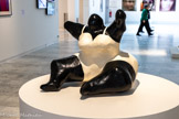<center></center>Niki de SAINT PHALLE
1930, Neuilly-sur-Seine (France) 2002, San Diego (États-Unis)
Nana assise
1971
Polyester peint
Inv.72.2.25 Achat 1972.
Après une enfance passée à New York, brièvement mannequin à la fin des années 1940, Niki de Saint Phalle revient en France en 1952 Tiraillée entre son aspiration à l’indépendance et le rôle de femme qui lui est destiné, elle est hospitalisée. La peinture, qu'elle pratique assidûment et la volonté de devenir artiste, constitueront pour elle une thérapie salutaire. Elle rejoint en 1961 les signataires de la déclaration constitutive du groupe des Nouveaux Réalistes, auxquels elle sera associée jusqu'en 1963. Cette période est celle des collages et des actions-tirs. Lors de ces peintures-happenings elle, ou le public, tire à la carabine sur des assemblages d'objets recouverts de plâtre et constituant des reliefs sur lesquels sont accrochées des poches de liquides colorés (peinture, encre, teinture).
En 1965 elle crée les premières Nanas. D'abord faites de fil, de laine et de tissu, elles seront suivies par d'autres en papier mâché puis en polyester. Cette figure ambivalente de la femme est à la fois martyre et ogresse aux épaules, aux seins et au sexe exagérés, à la tête et aux bras réduits. Saint Phalle en réalisera de multiples variations, telle la Nana assise. Presque à l'échelle humaine, cette œuvre combine plusieurs archétypes : poupée mais aussi statuaire africaine, proposant une ouverture à un imaginaire et un univers formel extra¬européen (art précolombien, afro-américain, indien, mésopotamien.), qu'elle systématisera et diversifiera par la suite.