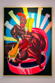 <center></center>Peter SAUL
1934, San Francisco (États-Unis)
La Twalette
1969
Huile et peinture métallisée sur toile
Inv. C.96.21
Legs donation Achfora D'Avis en hommage aux victimes du SIDA, 1996.
Peter Saul étudie à la California School of Fine Arts de San Francisco et à la Washington University School of Fine Arts de Saint-Louis.
À 22 ans, Saul quitte les États-Unis dont il ne supporte plus le moralisme puritain. De 1955 à 1965, il parcourt l'Europe. Il élabore une œuvre de rébellion iconographique, politiquement incorrecte. On y retrouve les formes du réalisme engagé (George Grosz, Otto Dix) et l'imagerie surréaliste (Salvador Dali, la période vache de René Magritte) associée à une crudité semblable à celle de son ami, dessinateur, Robert Crumb. Les artistes français de la Figuration Narrative revendiquent son influence.
L'artiste adopte une esthétique « gore », utilisant un mélange de peinture synthétique fluorescente. Il écrase, étire, ampute, transperce les formes et les figures, n'hésitant pas à déplacer les valeurs et les limites de la séduction et du monstrueux. Il peut aussi associer, dans les titres et dans un espace pictural hybride, des mots imitant la prononciation typiquement noire américaine pour donner une place à cette communauté.
La grande toile intitulée La Twalette, en hommage aux victimes du sida, reprend le contexte de la salle de bain, théâtre de sombres drames de sa peinture des années 1960. Black body-bullder condamné à la propreté hygiénique d'une Amérique blanche et clean, le héros de La Twalette pousse un cri dérisoire avec pour toute arme un éventail de brosses à dents et de rouleaux de papier toilette…