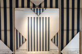 <center></center>Daniel BUREN
1938, Boulogne-Billancourt (France)
Cabane éclatée n° 2
1982
Bois, toile de coton à rayures verticales bleues et blanches, éléments projetés, serre-joints, acrylique blanche
inv.c.92.6 Achat 1992.À propos de la Cabane éclatée n°2, il explique : « Soit la construction d'une boîte de 420 cm de long par 280 cm de large en panneaux de 140 cm de large chacun par 280 cm de haut Chacun de ces châssis est tendu de tissu, ici blanc et bleu. Des dessins particuliers sont effectués dans ces châssis, permettant d'en ôter des fragments qui constitueront des 