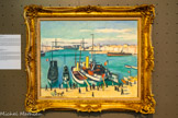 <center>Albert Marquet (1875-1947)</center>Le Vieux-Port et le pont transbordeur, 1918 Huile sur toile 66x81 cm.
Familier de Marseille où il a régulièrement séjourné, Marquet a notamment posé son chevalet à l'Estaque et autour du Vieux-Port. De ce dernier, il livre ici une vision caractéristique de son style fondé sur une gamme chromatique comme assourdie, ni sombre, ni éclatante, mais aussi sur des formes synthétisées et fortement cernées qui peuvent évoquer la patte de Louis-Mathieu Verdilhan, dont il fait d'ailleurs la connaissance en 1916.
L'œuvre est puissamment structurée par le jeu des verticales - silhouettes des passants, mâts des navires amarrés cul à quai, pylônes du pont transbordeur - et des horizontales - tablier de ce même pont front bâti du Quai du Port, vapeur longiligne sur la droite -, créant un espace dilaté où le plan d'eau paraît presque plus large que long. En cette période d'entre-deux-guerres, le Vieux-Port poursuit sa période transitoire, largement délaissé par les grands navires de commerce, sans être encore le pur bassin de plaisance qu'il est aujourd'hui devenu.