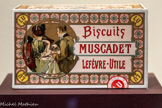 <center>Boîte pour les Biscuits Muscadet Lefèvre-Utile.</center>1901.
Boîte en fer-blanc recouverte d’une étiquette lithographiée en couleurs