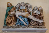 <center>Monestiès.</center>La Déploration. Groupe sculpté représentant hormis la Vierge et le Christ mort, six autres personnages : saint Jean à gauche, sainte Madeleine à droite, et quatre saintes femmes, soit huit personnages en tout