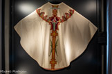 <center>La cathédrale Sainte-Cécile</center>Chasuble blanche.
Atelier des clarisses de Mazamet | vers 1957-1961 Soie brodée
Dépôt de l'archevêché d'AIbi
Cette chasuble n'est pas signée, mais les couleurs employées, l'originalité de la composition et l'influence style Art Déco permettent de l'attribuer aux clarisses de Mazamet.
L'arrière de la chasuble figure la colombe du Saint-Esprit descendant vers sainte Cécile. Les palmes nouées sur le bas rappellent son martyre.
Cette chasuble, offerte à Mgr Marquès dont elle porte les armoiries, est représentative du style plus dépouillé de la production des clarisses dans les années 1950.