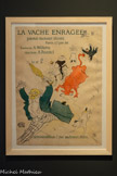 <center>Musée Toulouse-Lautrec</center>Henri de Toulouse-Lautrec
La Vache enragée
1896
Lithographie au pinceau, au crayon et au crachis, en quatre couleurs (pierre de trait en bleu, pierres de couleurs en turquoise, rouge et jaune)
Paris, musée des Arts décoratifs.
Toulouse-Lautrec réalise cette affiche pour le lancement du journal satirique La Vache enragée. Imaginé comme un mensuel, il ne connaît en réalité que deux éditions concomitantes à la « Promenade de la Vache enragée », dite aussi « Vachalcade » de la Butte Montmartre. Ce cortège carnavalesque de chars imaginés et décorés par des artistes a eu lieu en 1896 et 1897. Toulouse-Lautrec représente la vache chargeant le sénateur René Bérenger et poursuivie par un policier, sous les regards amusés d’un commis pâtissier et de deux clowns sur un tandem. Ce sénateur, surnommé « Le Père Pudeur », était détesté des Montmartrois en raison de sa campagne active contre les outrages aux bonnes mœurs.