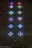 <center>Najac : Église Saint-Jean l’Évangéliste.</center>Les vitraux sont formés de dalles percées. Réalisés par un compagnon du nom de Barthélémy Gauchy à la fin du XIXe siècle, les vitraux de la nef prennent place dans des polylobes formés de dalles ajourées. Caractéristiques du courant artistique symbolique, ils présentent les attributs des quatre évangélistes, un calice, la colombe du Saint-Esprit et/ou encore le IHS du Christ. Par leur couleur extrêmement vive, ils apportent une luminosité tout à fait intéressante à l’édifice du XIIIe siècle dont l’architecture met essentiellement l’accent sur la ruralité.