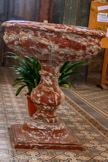 <center>Notre Dame de La Jonquière de Lisle-sur-Tarn</center>Bénitier. Marbre veiné (rouge, blanc), taillé. Cuve godronnée sur pied balustre en marbre rouge et blanc.