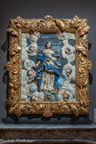 <center>Le musée Goya.</center>Anonyme
ECOLE ESPAGNOLE - XVIIIe SIÈCLE
L’Immaculée conception
S.D.
RELIEF AUX MIROIRS
BOIS DORÉ POLYCHROME, VERRE
Ce relief aux miroirs est une étonnante reconstitution d’un ensemble d’éléments sculptés assemblés au XIXe siècle, il évoque le thème de l’immaculée conception très populaire à partir du XVIIe siècle.
La partie centrale consacrée à la Vierge Marie est traitée en haut relief dans un style baroque. Le visage de la sainte présente la particularité d’avoir des yeux en verre, insérés au moyen d’une technique appelée « mascarilla » très utilisée en Espagne au XVIIe siècle. Selon l’iconographie du thème de l’immaculée conception, Marie, représentée avec de longs cheveux ondulés et détachés, descend du ciel. Elle est enveloppée dans son manteau bleu et repose sur le globe terrestre. Son pied droit est posé sur le croissant de lune tandis que son pied gauche écrase le corps du serpent.
DÉPÔT MUSÉE NATIONAL DE LA RENAISSANCE, LEGS AUDEOUD, ÉCOUEN, 2001