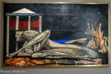 <center>Le musée Goya.</center>Oscar DOMÍNGUEZ
(LAGUNA, 1906 - PARIS, 1957)
L’Atlantide
S.D.
HUILE SUR ISOREL
L’Atlantide est le titre de ce tableau énigmatique peint par Oscar DomTnguez dans les années! 950 à la fin de sa vie. Dans cette composition simplifiée, l’œuvre se confond avec les origines de l’artiste né en 1906 aux îles Canaries dans cet espace de légendes où flotte l’esprit de la mystérieuse cité engloutie. Une figure de profil allongée occupe le premier plan de l’image. Cette chimère au corps de sauterelle et à la tête humaine repose sur le sol d’une nature hostile et menaçante réalisé dans une démarche quasi automatique, selon la technique de la décalcomanie. Artiste à l’œuvre singulière, provoquante et excessive, marqué par la disparition d’Eluard, Dominguez se donne la mort le dernier jour de l’année 1957.
