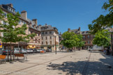 <center>Place du Bourg</center>Une des deux places les plus réputées du centre bourg de Rodez. C'est la place des Comtes en lutte avec celle des Evêques (place de la Cité). Au fond, lCe buste en bronze de Denys Puech rend hommage à un tailleur né à Rodez en 1778. Formé au métier par son père, tisseur de draps,
Blazy Bou fait fortune à Paris sous le patronyme de « Lebon ». L'histoire de la ville resta marquée durant longtemps par une intense rivalité entre les comtes de Rodez, maîtres du Bourg, et les évêques de Rodez, maîtres de la Cité. Une muraille délimitait les deux secteurs. Chaque communauté avait un hôtel de ville, ses consuls, une administration propre ; chacune rivalisant de puissance, de rayonnement. Au bourg, la célèbre dynastie des comtes d'Armagnac et de Rodez, finit par acquérir des privilèges régaliens. En 1443, le dauphin, futur Louis XI, vint occuper Rodez et soumettre le comte Jean IV. Plus tard, son fils aura une idée séditieuse en essayant de trahir Louis XI. Cela lui vaudra d'être massacré à Lectoure, avec sa famille, lors de sa fuite.