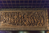 <center>Scène de traite.</center>Création de M. Ulika Valentim. 1975.
Panneau sculpté en bas-relief et ajouré, représentant une colonne d'esclaves encadrés par des négriers arabes. On estime que cette traite à concerner environ 17 millions d'Africains entre 650 et 1920.