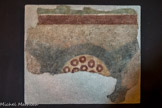 Site paléochrétien de Saint-Seurin <br> Une peinture murale. Elle montre un simple cercle ocre jaune ocellé de ronds marron et les traces d’une étoile à quatre branches noires sur un fond rose pâli. L’interprétation de cette fresque est énigmatique mais la facture est typique du Bas-Empire romain.