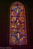 <center>L'apocalyse. </center> Pas de donateurs.

Trois étages comportant chacun un médaillon central entouré de quatre médaillons. Dans chaque médaillon central : une représentation du Christ en majesté. Les médaillons qui entourent les trois figures du Christ sont conçus en fonction de celui-ci. Il y a hiérarchie et symétrie.

Première figure du Christ (Ap. 1, 12-16 et 5, 1). au-dessus, sept anges : les sept Églises d'Asie Mineure, symbolisant l'Église universelle. En dessous, à droite, un personnage (Saint Paul ?) baptisant, à gauche un groupe entourant une femme couronnée. Ce dernier médaillon n'est probablement pas à sa place.

Seconde figure du Christ  sur un trône entouré de 24 vieillards (Ap. 4, 2-4). De ses mains partent des flammes qui se répandent sur les personnages placés en dessous : les Apôtres le jour de la Pentecôte. Les douze autres au-dessus seraient les prophètes (Tables de la Loi).

La troisième figure du Christ dans une mandorle tenue par deux anges évoque la deuxième Parousie dans la disposition de l'Ascension (Actes 1, 11). Sous cette figure, à droite, un groupe symétrique de celui placé en bas du vitrail et qu'il faudrait placer ici, le médaillon représentant Saint Pierre semblant remettre les péchés prenant sa place en bas, en face de Saint Paul ... Mais on peut rétablir la symétrie de façon inverse, ce qui conduit à une interprétation autre.

Au-dessus : l'Agneau vainqueur (Ap. 17, 14) et une femme couronnée (l'Église ? la Sagesse?) nourrissant de son lait deux personnages (Ancien et Nouveau Testament ?). Tout en haut enfin : sept étoiles. Les sept dons de l'Esprit ? L'Église universelle ? Il reste beaucoup à faire ...