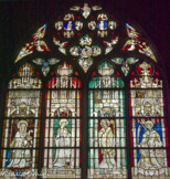 Vitrail de 1412. St Julien de Brioude (?) et l'apôtre st Simon qui présente à ste Catherine et st Hilaire de Poitiers Simon Aligret et ses deux neveux. Aligret avait été trésorier de l'abbatiale Saint-Hilaire de Poitiers. Le couronnement des baies est occupé par un jugement dernier
