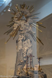 <center>Paray le Monial </center>Via Vitae. <br> La Crucifixion et La Résurrection. Au sommet, l’Eucharistie présentée par deux allégories féminines : l’Amour, dont l’attribut est un sceptre surmonté de deux cœurs, et l’Harmonie dans l’attribut est une harpe. L’hostie sertie de diamants fait transparaître en rubis le monogramme du Christ et JHS (Jésus Sauveur des hommes). En partie sommitale, les rayons de la gloire divine entourent le triangle, Trinité de Dieu, en cristal de Roche.