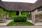 <center>Le Clos Vougeot</center>Intérieur du cloître de la cuverie du château. Le porteur de benaton, du sculpteur bourguignon Henri Bouchard, montre un vendangeur portant sur l'épaule le benaton, un panier à vendange en osier pouvant contenir40kg de raisins.