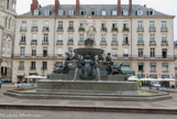 <center>La place Royale. </center> Erigée en 1865, la fontaine monumentale, en granit bleu, symbolise la vocation fluviale et maritime de Nantes. La ville, sous les traits d'une femme couronnée, armée du trident de Neptune qui a disparu, veille sur la Loire et ses affluents l'Erdre, la Sèvre, le Cher et le Loiret. Huit génies de l'industrie et du commerce rappellent le rôle majeur du port dans l'économie de la cité.