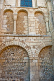 <center>Abbaye de Nouaillé-Maupertuis. </center> Deux étages d'arcades recouvrent aujourd'hui ce mur nord, avec son appareil de petites pierres cubiques. Au début du XIIe siècle, les murs extérieurs, trop faibles pour supporter un voûtement de pierre, sont renforcés par de solides contreforts.