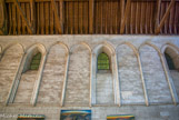 <center>Le palais et la tour Maubergeon. </center> Sur les trois murs de cette époque (est, nord, ouest), elle présente une décoration très caractéristique du style gothique angevin (arcatures aveugles, chapiteaux à crochets, masques, bases ornées) que l'on retrouve à la cathédrale Saint-Pierre et dans la nef de l'église Sainte-Radegonde. D'une coté les arcatures sont en arc brisé.