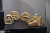 <center>Musée archéologique de Tarente</center>A gauche, oscilla. Décorés de différents motifs, ils étaient utilisés pour le tissage. 0 droite, poids de métiers à tisser. IIème-Ier siècle avant J.-C.