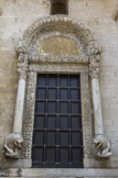 <center>Basilique Saint-Nicolas de Bari.</center>Entre autres sculptures intéressantes, celle du bandeau interne de l’arc qui la surmonte. Il représente une scène de guerre où des cavaliers en armure prennent d’assaut une citadelle représentée par une porte barricadée, au-dessus de laquelle apparaissent les têtes de deux défenseurs. En 1098, Bohémond, un fils de Robert Guiscard (