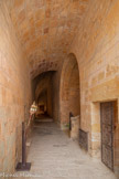 <center>Abbaye de Fontfroide.</center>La ruelle des convers. Elle sépare deux mondes. L'espace sacré des moines s'ouvre derrière le mur de clôture à gauche, à l'abri des regards et du bruit. De ce côté-ci, les va-et-vient sont incessants car la ruelle, voûtée en demi-berceau, est pour les convers le passage obligé pour rejoindre la cour des ateliers, le réfectoire, le dortoir, le cellier ou aller à l'église. A droite, la porte du réfectoire des convers. Tout au bout de la ruelle, une petite porte mène à l'abbatiale. Entre les deux, une autre permet l'accès au cloitre.
Le dimanche et les jours de fêtes, elle permet aux convers de prendre place au fond de la nef, pour assister à la messe sans déranger les moines placés à l'autre bout, plus près du chœur.