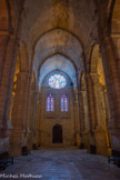 <center>Abbaye de Fontfroide.</center>L'abbatiale. La construction de la nef fut entreprise dès l’affiliation à Cîteaux en 1145 ou, au plus tard, après la donation définitive par la vicomtesse Ermengarde de Narbonne en 1157. Contrairement aux usages, on commença les travaux par la nef. Rythmée par cinq travées, la nef élève jusqu’à vingt mètres sa voûte en berceau brisé que soutiennent de massifs doubleaux rectangulaires. Ces arcs prennent appui sur des colonnes géminées, engagées dans de gros piliers carrés et s’arrêtant sur des consoles en quart de rond, à deux mètres du sol. Dès l'entrée, l'abbatiale exprime la force spirituelle de Fontfroide et sa dynamique artistique. Ce qui ne se voit pas à l'œil nu, son acoustique, invite à se placer au centre de la nef pour entonner un chant qui voyagera, limpide, dans ce majestueux vaisseau. L'église est le lieu de la louange. Les moines chantent, assis, face à face dans le haut de la nef, non loin du chœur. Les frères convers sont au fond, séparés d'eux par la 