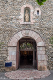 <center>Église Saint-Pierre de Prades</center>La porte est surmontée d'une statue de saint Pierre dans une niche.