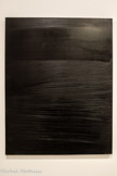 <center>Peinture 162 x 114 cm, 27 février 1979</center>Huile sur toile
Montpellier, musée Fabre, donation Pierre et Colette Soulages, 2005. <br> Cette toile est la première conservée où le noir monopigmentaire - un noir d’ivoire en pâte épaisse - couvre totalement la surface du support. Deux outils différents- pour les stries, un pinceau, pour les aplats, une lame - imposent à la lumière des incidences changeantes. Soulages réussit une sorte d’alchimie de la matière : le noir opaque est « transmué » en lumière comme le dit Colette Soulages quand elle voit dans l’atelier, un matin de l’année 1979, le premier Outrenoir : « Mais jamais personne n’a fait cela. C’est tout à fait nouveau. Quelle audace ! Il y en a beaucoup qui ont fait des monochromes, mais ça n’a rien à voir, ce n’est pas un monochrome, c’est de la lumière réfléchie ».
