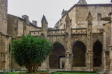 <center>Cathédrale Saint-Just-et-Saint-Pasteur</center> Le cloitre. Ce cloître gothique relie le Palais des Archevêques au chœur fortifié de la cathédrale. Il fut construit à l’emplacement de la nef de l’ancienne cathédrale préromane dont la tour, dite “de Théodard”, est le seul vestige visible. Les travaux commencent vers 1350 (galeries nord, est et ouest) puis, après une interruption, reprennent en 1417 (galerie et porte sud – côté Palais).