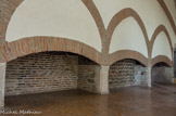 <center>Palais des Rois de Majorque.</center>Grande salle ou Aula. Elle conserve sa cheminée près de laquelle un escalier communiquait avec les cuisines au rez-de-chaussée. Deux foyers en briques encadrent un brasero.