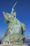 <center>Le Pharo.</center>Le Monument aux héros et victimes de la mer.  Le troisième est noyé, emporté par une vague qui incline fortement la barque des marins et qui balaie un récif en granit.