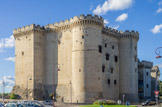 <center>Le château de Tarascon</center>Il se compose de deux parties bien distinctes : au sud le logis proprement dit. Nous avons en façade avant deux tours rondes, ce qui est plus Français que Provençal. Celle de droite est la tour de l'Horloge, ainsi appelée parce qu'elle abritait un mécanisme d'horlogerie. L'autre est la tour des chapelles. Elle contient la chapelle basse et la chapelle royale, du moins leurs absides, les nefs se développant dans l'aile sud.  La haute-cour est la partie militaire et seigneuriale. En tant que telle, elle est plus défendue et plus luxueuse. On voit d'ailleurs bien la différence de hauteur entre les deux parties. Le logis seigneurial n'a pas de rempart. C'est la hauteur des étages d'habitation qui sert de rempart, d'autant que les tours sont partiellement engagées dans la construction. Elles ne font qu'un avec les bâtiments. Pas de fenêtres en bas, d'autant plus que c'est au-dessus du rez-de-chaussée, étant donné qu'il y a des
caves. Les fenêtres du rez-de-chaussée sont petites, de même que celles du troisième étage, mais parce que c'est l'étage de la domesticité. Les fenêtres des étages intermédiaires sont Renaissance avec des larmiers. Elles furent grillagées lorsque c'était une prison.