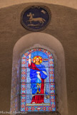 <center>L'Église Saint-Christophe.</center>Vitrail de EM. Teissier, représentant le Christ. Au-dessus, les armoiries de la Chartreuse de Montrieux, partenaire de la construction de l’église.