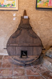 <center>Le musée du Patrimoine.</center>Ancienne forge. Un soufflet. Une forge de village comportait un ou deux foyers où le métal était mis à rougeoyer. Depuis des siècles, on utilisait le charbon comme combustible. A l'aide de soufflets, on entretenait son incandescence. Ces soufflets de forge étaient autrefois faits de cuir. Ils étaient sur du bois en palettes. Dès la fin du 19ème siècle, ils furent remplacés par des soufflets à cylindres métalliques et à 2 pistons articulés.
Proches des feux se trouvaient les enclumes, sur lesquelles, manches retroussées et protégé par un grand tablier de cuir, le forgeron façonnait le métal à sa guise, le tordant à l'aide de grosses pinces, puis le martelant à l'aide de masses plus ou moins lourdes. L'outillage du forgeron comprenait des marteaux, des cisailles, des limes (la lime apparut dès le 14ème s.) etc.
Il était celui qui cerclait les tonneaux, les seaux de bois. Il pouvait tout aussi bien jouer le rôle du rémouleur, du rétameur, et il rebouchait à l'étain les casseroles trouées et autres ustensiles de cuisine.