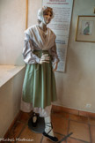 <center>Le Musée du vêtement Provençal</center>Le costume féminin.
La paysanne, la païsano vit dans un logis modeste et travaille comme son mari à la campagne. Selon les saisons elle cueille les olives, lie les gerbes de blé, vendange. A cause du dur labeur la paysanne se confectionne des vêtements dans des matières dures comme le chanvre qu’elle file et porte ensuite chez le tisserand qui en fabrique une toile solide. Par souci d’économies elle porte ses vêtements jusqu’à une extrême usure. Sa robe portait des rayures.
L'artisane, tient la boutique de son mari qui fait vivre la famille de son art. L’artisan est très souvent propriétaire de ses biens. Les tissus du costume de l’artisane par rapport à la paysanne sont de très bonne qualité et étaient fleuris..
La bastidane, la bourgeso est la femme du ménager. Son mari est propriétaire de ses terres. Elle s’occupe de l’intendance du domaine et aide les bonnes œuvres. Son costume est très proche de la mode parisienne.