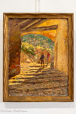 <center>Centre d’art Sébastien</center>Gabriel Amoretti (1861-1947)
Vieille rue à la Garde, 1919
Huile sur carton
33,8 x 26,3 cm
Collection Musée de la Banque, Hyères. <br> Gabriel Amoretti (1861–1947)
Classé dans un courant post-impressionniste, il est
essentiellement rattaché à l'école de Toulon.
Né à Toulon et formé dans ses ateliers locaux, Amoretti
revient dans le Midi et devient directeur de l'École des
Beaux-Arts de Toulon, formant plusieurs générations
d'artistes de la région.
Son œuvre manifeste d'abord de fortes réminiscences
de l’école de Barbizon, notamment dans le rendu
réaliste des troupeaux. Puis, à son retour dans le Midi,
il adopte une touche plus libre, des coloris lumineux et
un style post-impressionniste.