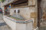 <center>Lavoir et Fontaine rue Kléber</center>C‘est la première des deux basses fontaines.
En effet, cette rue s’appelle également la rue des basses fontaines. Elle se trouve juste en contrebas de l’ancien rempart et de l’ancienne place aux bestiaux du village. Cette fontaine trouve sa source à pratiquement 2 km plus loin, et, lorsque le seigneur de Cadenet décida de l’installer en 1535, ce fut un progrès énorme pour le village. À cette époque, pas de lavoir. Il fut installé à la fin du XIXe siècle pour permettre aux femmes du quartier de ne pas avoir à se rendre trop loin pour laver leur linge. Si vous vous mettez sur la grille qui se trouve devant la fontaine, vous pourrez presque avoir le vertige : en dessous se trouve une descente d’eau, qui permet à un ruisseau, un « Vabre », de s’écouler vers la Durance. Elle a deux crachoirs en fonte en forme de tête humaine.