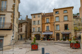 <center>Place du Tambour d'Arcole.</center>Jusqu’au début du 19ème siècle, cette place, dite place aux bestiaux, se situait à l'extérieur de l'enceinte fortifiée. On s'y réunissait pour le marché aux animaux afin de préserver le village des odeurs et désagréments pouvant causer des problèmes sanitaires. Il faudra attendre la fin du siècle pour que la place devienne un point central de la vie du village.
Autour de la statue du Tambour d’Arcole, il y avait divers commerces et pas moins de quatre cafés et un cercle musical Coco Perrin. Après une grosse journée de travail, les ouvriers vanniers s’y retrouvaient et y dépensaient une part, voire la totalité, de leurs salaires et de leurs « tripes » (avance sur salaire par semaine), avant de rentrer chez eux.