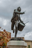 <center>Statue du Tambour d’Arcole </center>André Estienne, de son vrai nom, est né le 13 octobre 1777 à Cadenet dans une famille modeste de paysans.
Grâce à ses talents musicaux André s’engage à 15 ans dans le bataillon du Luberon de l’armée de Napoléon comme Tambour afin de subvenir aux besoins de sa famille. Cette carrière dans l’armée va littéralement bouleverser sa vie !
 Aux côtés du tambour maître Vincent Noël il progresse et le 15 novembre 1796, lors de la campagne d’Italie, il est présent à la Bataille d’Arcole.
19 000 soldats de l’armée de la République Française affrontent les 24 000 hommes de l’armée de l’empire autrichien. La bataille fait rage autour du pont d’Arcole.
André Estienne traverse à la nage avec quelques soldats la rivière, son tambour, hors d’eau, posé sur le sac de son sergent et, battant furieusement la charge sur l’autre rive, fait croire aux autrichiens qu’ils sont encerclés. Ceux- ci battent en retraite, laissant le pont et la victoire aux armées de Napoléon Bonaparte.