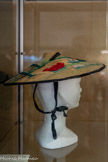 <center>Musée de la vannerie</center>Chapeau de femme dit « Coiffure Niçoise » au paysage brodé de laine.
Nice 1940
Chapeau en paille tressée, brodé de laine polychrome sur décor peint à la main, représentant un paysage, bordé en velours noir, ruban  de velours noir se lassant sous le menton