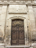 Portail de la chapelle du Grand-Couvent des bénédictines.  La porte principale est en bois, sculptée de chérubins et du profil de saint Benoît